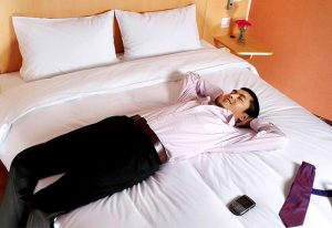 Relaxing at Ibis Shanghai Xujiahui Hotel. Gay-friendly hotel room with man resting on bed. Comfortable stay in Shanghai for gay travelers.