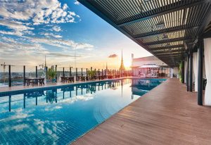 NagaWorld Hotel & Entertainment Complex rooftop pool at sunset. Gay-friendly hotel with luxury amenities. Perfect for gay travel and relaxation.
