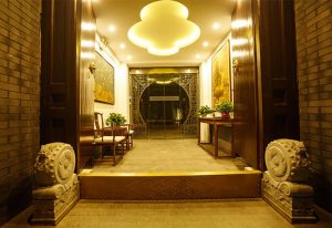 Entrance of PUREMIND Hutong Courtyard Hotel, a gay-friendly hotel. Traditional Chinese decor, stone lions, and ornate doorway. Beijing travel.