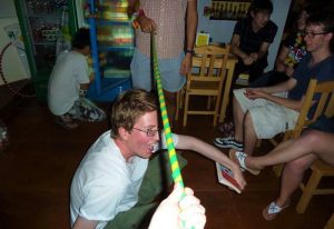Gay-friendly Shanghai Blue Mountain Youth Hostel Luwan: Men play limbo at the hotel. A fun, inclusive travel experience in Shanghai, China.