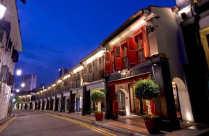 The Scarlet Singapore Hotel facade at night. Gay-friendly hotel with red shutters, street view. Boutique hotel for gay travelers in Singapore.