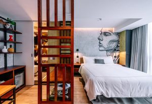 The Sheung Wan hotel room. Modern design with a bed, wooden screen, and artistic wall mural. Gay-friendly hotel in Sheung Wan, Hong Kong.
