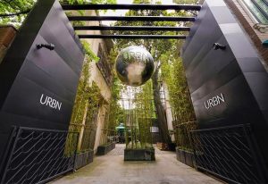 URBN Boutique Shanghai entrance. Gay-friendly hotel with bamboo decor and a large URBN sphere. Modern design, welcoming atmosphere.