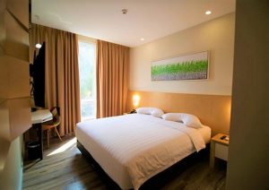 Verse Luxe Hotel Wahid Hasyim room. Gay-friendly hotel bedroom with a large bed, desk, and window. Modern design for gay travel in Jakarta.