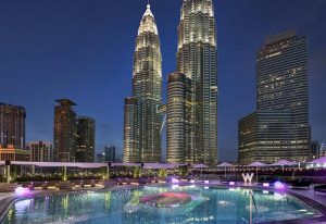 W Kuala Lumpur gay-friendly hotel pool at night. Petronas Towers backdrop. Luxury travel for gay men in Malaysia.