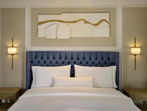Dublin gay-friendly luxury hotel room at The College Green Hotel, Autograph Collection. Blue headboard, white linens, modern art.