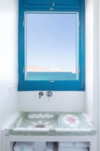 Belvedere Little Venice Pied-a-Terres bath. Blue window frames sea view. Terrazzo sink, towels. Gay-friendly hotel bathroom design.