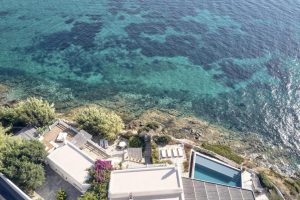 Aerial view of Belvedere Mykonos Waterfront Villa & Suites, a gay-friendly hotel, with pool and ocean views. Ideal for gay men travel.