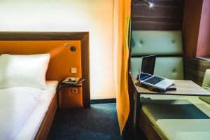 Cocoon Sendlinger Tor gay-friendly hotel room. Modern design with bed, workspace, and laptop. A comfortable stay in Munich for gay travelers.