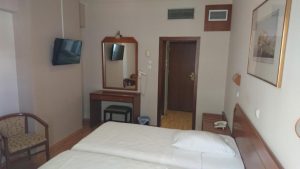 Economy Hotel room with twin beds, desk, chair, and TV. Gay-friendly hotel option for budget travelers.