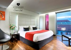 Eurostars Grand Central Hotel room. Gay-friendly hotel with a bed, chair, and large window. Clean and safe hotel for gay men travelers.