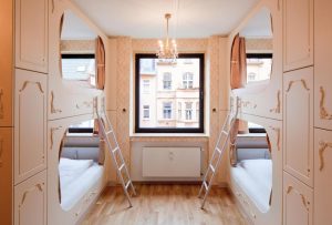 Hostel die Wohngemeinschaft room. Gay-friendly hotel with bunk beds, ladders, and a window. A unique lodging choice for gay travelers.