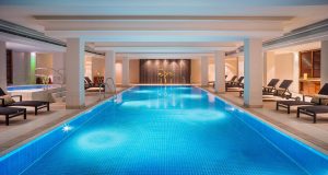 Le Méridien Munich's indoor pool. This gay-friendly hotel features a relaxing pool area with lounge chairs for a luxurious stay.