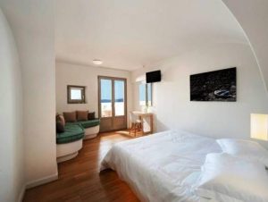 Panorama Boutique Hotel room. Gay-friendly hotel room with bed, couch, desk, and balcony. Modern, clean design for gay travelers.