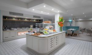 The Fleet, a gay-friendly hotel: Breakfast buffet area with food selections, flowers, and seating. A great spot for gay men's travel.