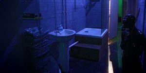 The Bunker London interior. Sink, shower, and figure in a dark room. Gay cruise club, private appointment only. Gay travel advice.