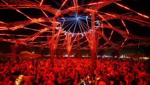Wonderfruit Festival Thailand crowd in Pattaya. Red lights illuminate the gay-friendly event. Travel advice for LGBT men.