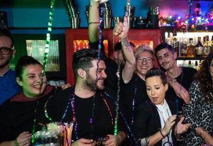 Myrovolos bar staff celebrating, gay travel destination. Group of happy people, bar scene, nightlife. Myravolos party, fun, and camaraderie.