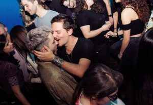 Noiz Athens: Gay couple kissing in a crowded club. Nightlife scene at Noiz, a gay bar in Athens, Greece. Gay travel advice photo.