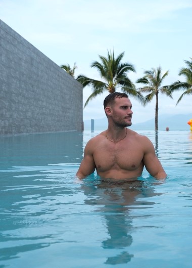 Gay man in private pool at Koh Samui adults-only resort. Explorar Hotel offers private pool villas for gay travelers seeking luxury and relaxation.