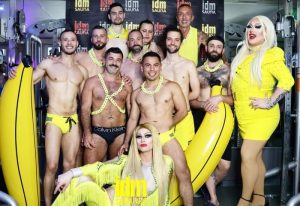 Paris Gay Sauna: Group of men and drag queens in yellow at IDM Sauna. Celebrating gay travel, fun, and community.