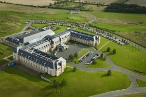 Fairmont St Andrews, Scotland: Aerial view of a gay-friendly hotel. The large, elegant building is surrounded by green lawns and parking areas.