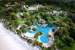 Aerial view of The Barai By Hyatt, a gay-friendly hotel. Pools, lush gardens, beach, and Thai-style architecture create a luxurious resort experience.