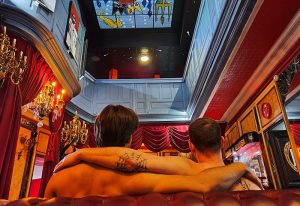Les Bains Paris: Gay couple in luxurious bathhouse. Ornate decor, chandeliers, and unique ceiling art. Gay travel advice.