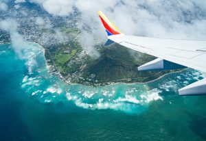 Aerial view of Honolulu, Hawaii from a plane's wing. Gay Honolulu travel guide, number one gay destination. Turquoise ocean, Diamond Head.