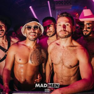 MadMen XLSIOR Mykonos: Shirtless men at a gay party. Nightlife scene, partygoers, and vibrant atmosphere. Gay travel, Mykonos events.
