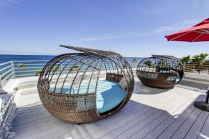 Gay-friendly hotel rooftop with unique lounge chairs offering ocean views. Perfect for snoozing in style. A luxurious, relaxing vacation spot.