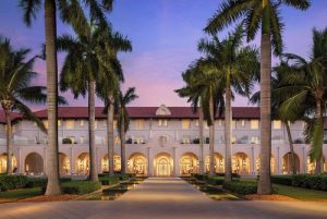 Casa Marina Key West, a Curio Collection by Hilton, gay-friendly hotel. Exterior view with palm trees at dusk. Gay travel advice.
