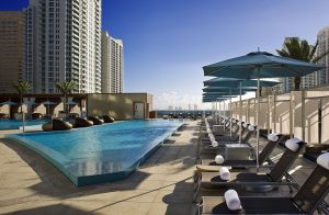 Kimpton EPIC Hotel's rooftop pool and lounge chairs. A gay-friendly hotel in Miami. Perfect for gay men travel advice.