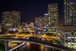 Downtown Brickell-Port of Miami at night. View from a gay-friendly hotel. Cityscape with illuminated buildings and waterways.