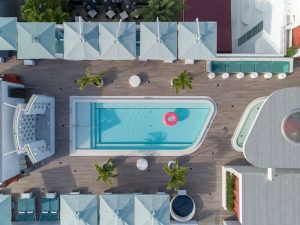 Dream South Beach, a gay-friendly hotel: aerial view of the pool with a pink float, umbrellas, and lounge chairs. Part of Hyatt hotels.