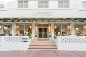 President Hotel, a gay-friendly hotel. Exterior view of the entrance with steps, outdoor seating, and The President sign above the doorway.