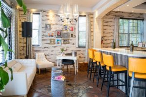 Hotel Shelley's gay-friendly interior. Lounge area with white sofa, yellow bar stools, and eclectic decor. A welcoming space for gay travelers.