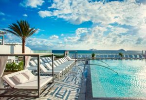 Most popular gay hotel in Fort Lauderdale this year: Poolside view of a luxury hotel with beach access and lounge chairs.