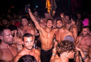 Gay men's travel advice: A packed dance floor at SCORE gay bar, featuring shirtless men. Nightlife scene. 1-23.jpg