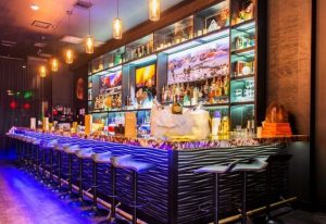 Nathan's Beach Club bar interior. Stylish bar with stools, liquor shelves, and ambient lighting. Gay travel destination. 1-26.jpg