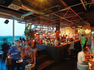 Interior of 25Hours Bikini Berlin, a gay-friendly hotel. Guests at the bar, enjoying drinks. Great view from this Berlin hotel.