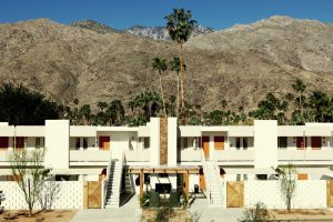 Ace Hotel and Swim Club Palm Springs view. Gay-friendly hotel with mountain backdrop. Modern architecture, palm trees, and desert landscape.