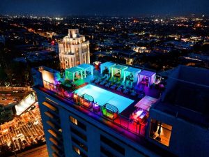 Andaz West Hollywood's rooftop pool at night. A gay-friendly hotel with colorful lights, cabanas, and city views. Perfect for gay travel.