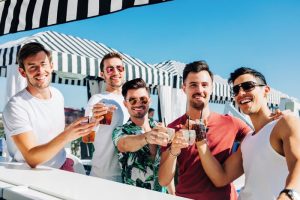 Montrose at Beverly Hills gay-friendly hotel: Group of gay men toasting drinks at the bar. A luxury travel experience for gay travelers.