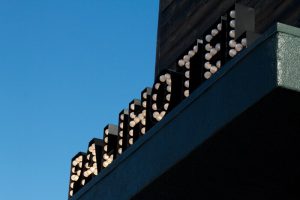 Palihotel Melrose sign. Gay-friendly hotel in Melrose, Los Angeles. The hotel's name is spelled out with illuminated bulbs against a bright blue sky.