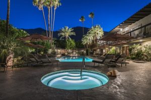 Santiago Resort, Palm Springs: Gay-friendly hotel with a pool and jacuzzi under palm trees at night. Premier gay men's resort for relaxation.