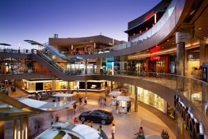 Shopping mall near Shore Hotel, a gay-friendly hotel. Multi-level retail space with escalators, shops, and restaurants. Modern architecture and bustling atmosphere.