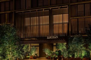 The West Hollywood EDITION hotel facade at night. Gay-friendly travel destination with modern architecture and lush greenery. Upscale and inviting.