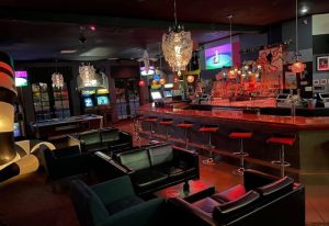Interior of Bart Lounge, a gay bar. Features include a bar, seating, pool table, arcade games, and TVs. Good for gay men travel advice.