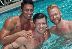 Flex LA Experience: Three smiling gay men in a pool. Travel to Los Angeles for a fun gay vacation. Summer vibes, sun, and friendship.